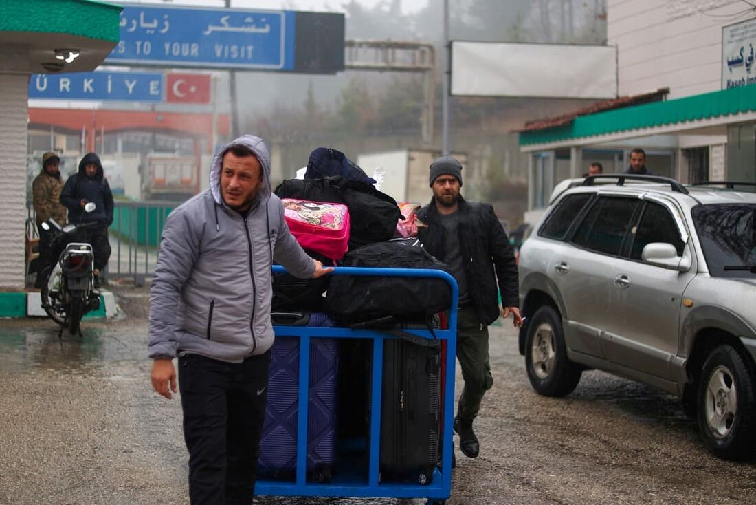 Pessoas cruzam para a Síria vindas da Turquia pela passagem de Kassab.