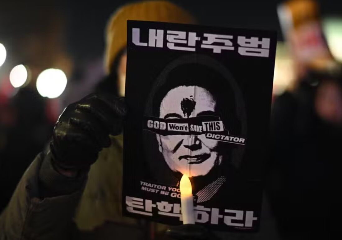 Manifestante segura cartaz com crítica a presidente Yoon Suk-yeol