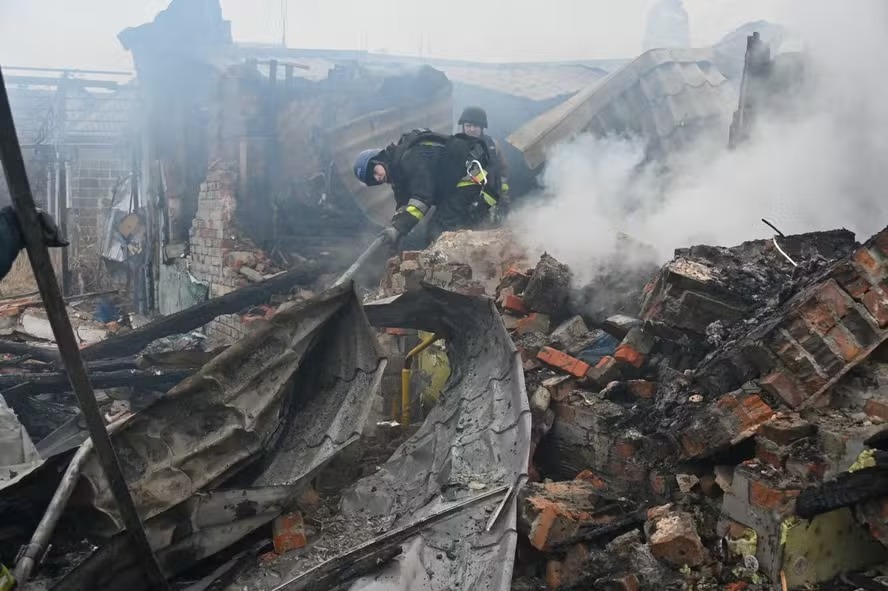 Equipes de resgate trabalham para apagar incêndio em casa particular após ataque de drone em Kharkiv, Ucrânia 