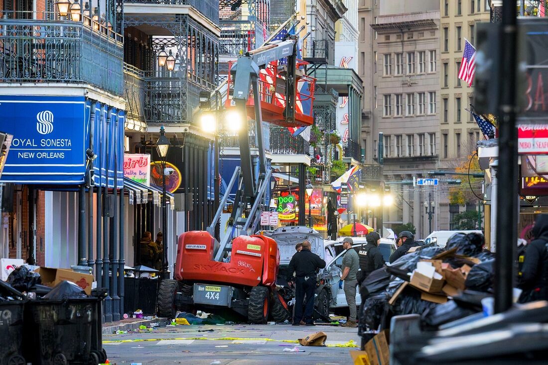 Investigadores da polícia cercam um caminhão branco que colidiu com um elevador de trabalho no French Quarter de Nova Orleans, Louisiana