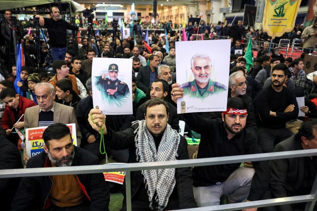 Iranianos seguram retratos do comandante da Guarda Revolucionária assassinado, Qasem Soleimani, durante uma cerimônia na capital Teerã.