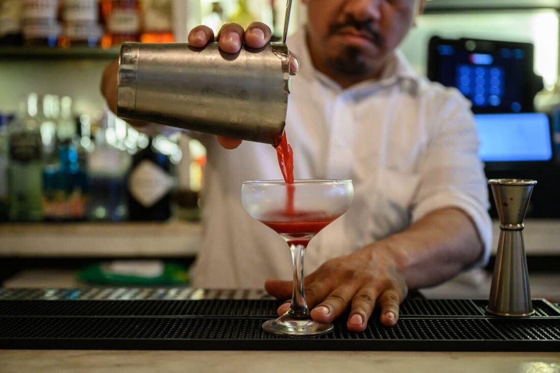  Um barman serve um coquetel em um restaurante na cidade de Nova York