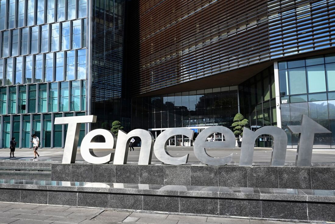 Esta foto tirada em 10 de julho de 2022 mostra pessoas passando pela sede da Tencent em Shenzhen, na província de Guangdong, no sul da China