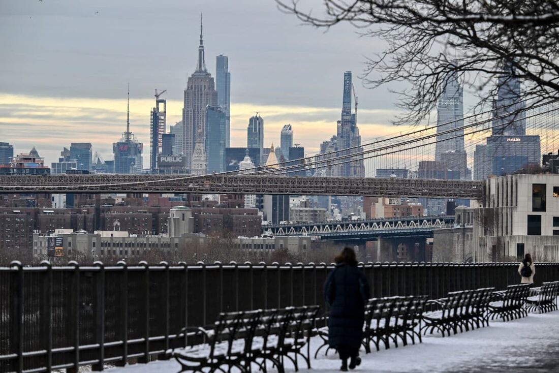 O Empire State Building é visto enquanto as pessoas andam na neve na cidade de Nova York em 6 de janeiro de 2025, após uma tempestade de inverno atingir a região do Meio-Atlântico.