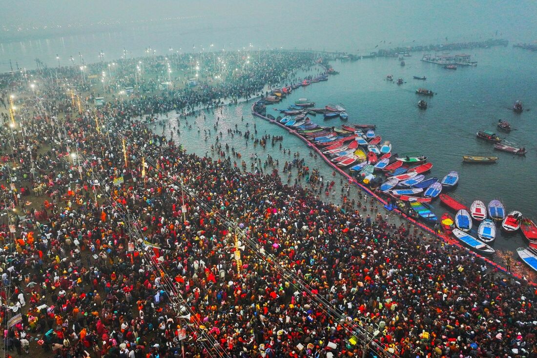 Peregrinos hindus dando um mergulho sagrado nas águas sagradas de Sangam, a confluência dos rios Ganges, Yamuna e os míticos rios Saraswati, durante o festival Maha Kumbh Mela, em Prayagraj