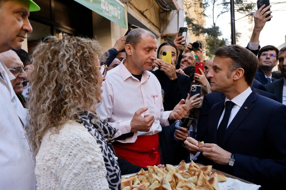 O presidente da França, Emmanuel Macron (R), prova a comida oferecida pela equipe do restaurante Le Chef durante uma visita ao distrito de Gemmayze, em Beirute, em 17 de janeiro de 2025