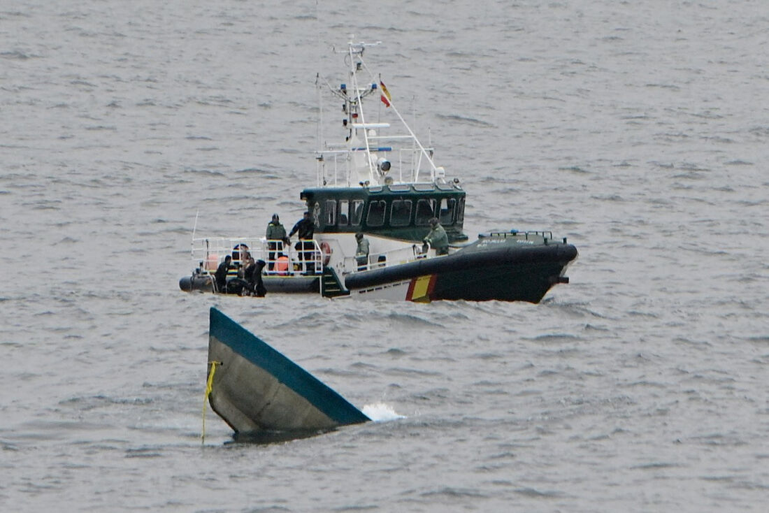 Um barco da Guarda Costeira Civil se aproxima da proa de um suposto narcossubmarino, descoberto na manhã de 22 de janeiro de 2025, emergindo da água no estuário de Muxia-Camarinas