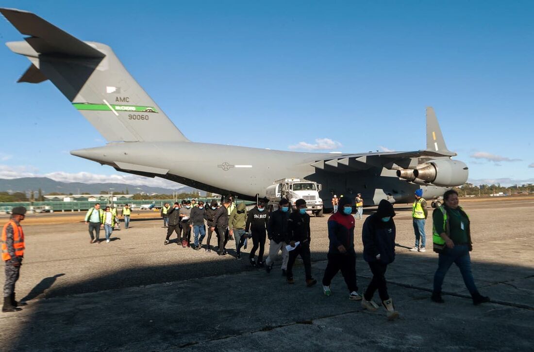 Migrantes guatemaltecos descendo de um avião militar dos EUA após serem deportados dos EUA na Base Aérea da Guatemala