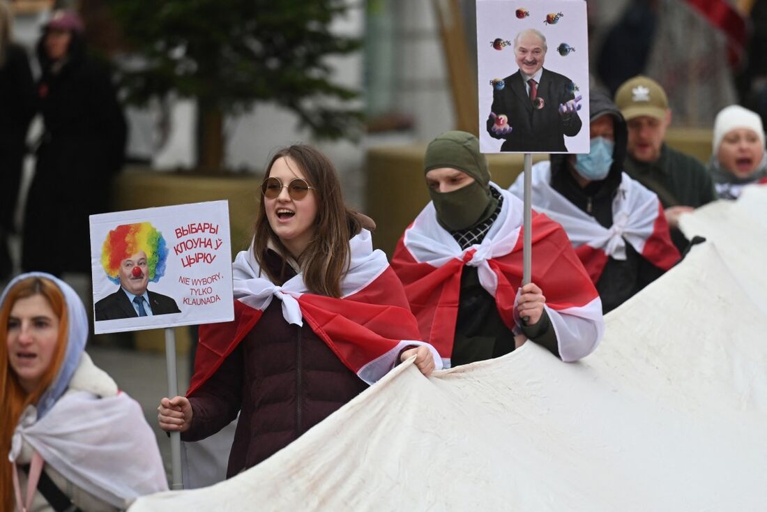 Membros da diáspora bielorrussa carregam cartazes representando o presidente da Bielorrússia, Alexander Lukashenko, durante um comício em Varsóvia