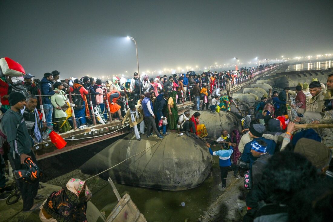 Peregrinos se reúnem em uma ponte flutuante perto do local de uma debandada em meio ao festival Maha Kumbh Mela em Prayagraj