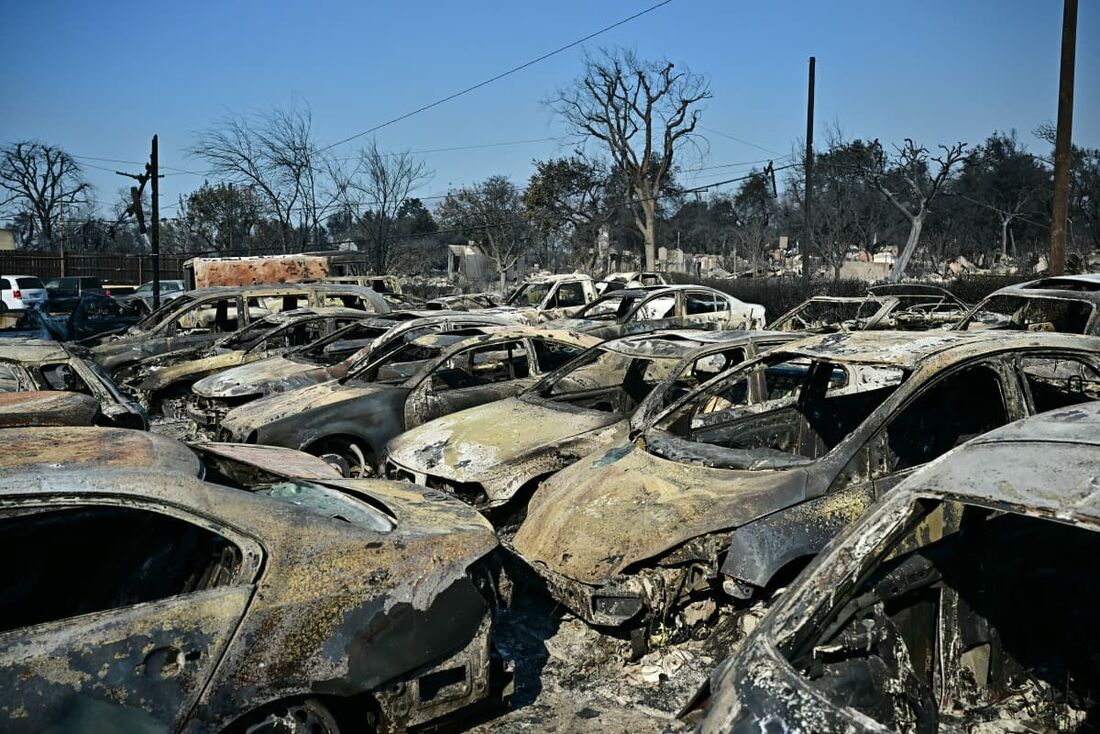 Carros pertencentes à concessionária Altadena Auto Center destruída pelo incêndio Eaton permanecem estacionados em um estacionamento, em Altadena, Califórnia