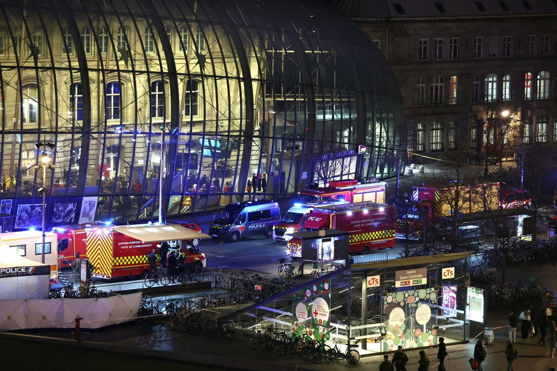 Veículos de bombeiros e resgate estão estacionados do lado de fora da estação ferroviária de Estrasburgo após uma colisão de dois bondes