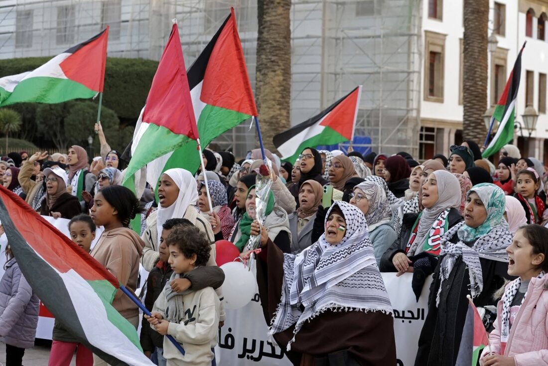 Manifestantes comemoram enquanto se reúnem em frente ao prédio do parlamento para expressar seu apoio aos palestinos