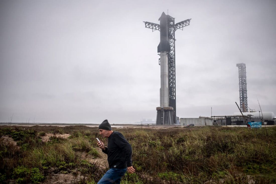 Um visitante caminha perto do local de lançamento do foguete SpaceX Starship