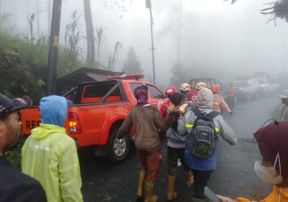 Equipes de resgate e moradores evacuando vítimas de um deslizamento de terra na vila de Kasimpar em Pekalongan, Java Central, na Indonésia