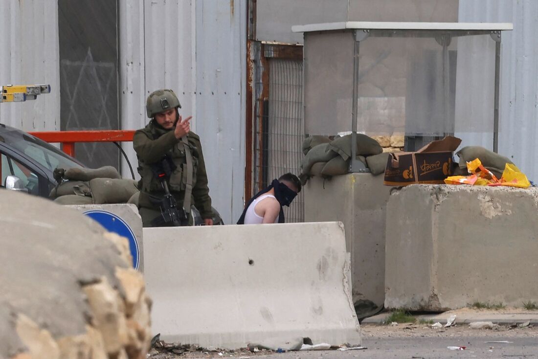 Tropas israelenses detêm um homem palestino em um posto de controle enquanto as autoridades israelenses fecham uma entrada para a cidade ocupada de Hebron, na Cisjordânia, em 22 de janeiro de 2025