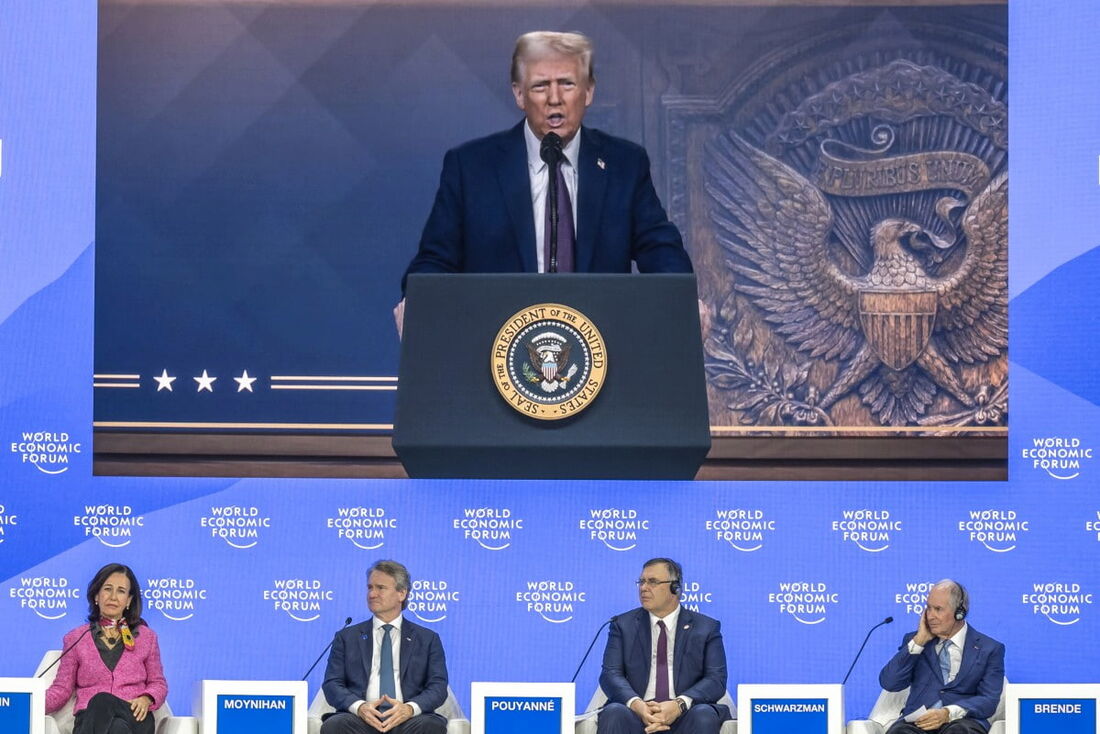 O presidente dos EUA, Donald Trump, aparece em uma tela gigante enquanto se dirige às elites globais por videoconferência no Fórum Econômico Mundial em Davos