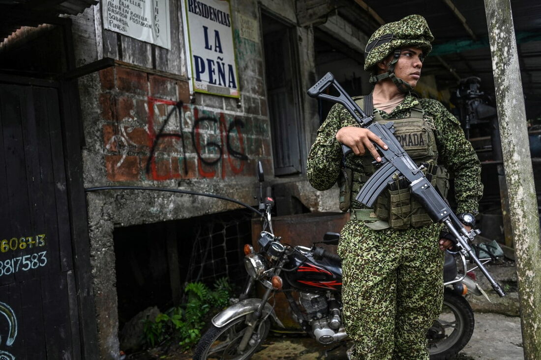  Um soldado colombiano monta guarda ao lado de grafites das Forças de Autodefesa Gaitanistas da Colômbia (AGC) 