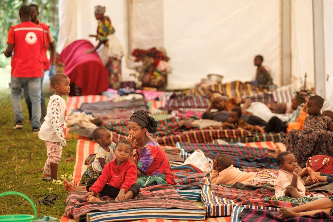 Refugiados congoleses que fogem dos confrontos em curso no leste da República Democrática do Congo descansam em colchões dentro de uma tenda ao chegarem ao campo de trânsito de Rugerero, em Gisenyi, em 28 de janeiro de 2025