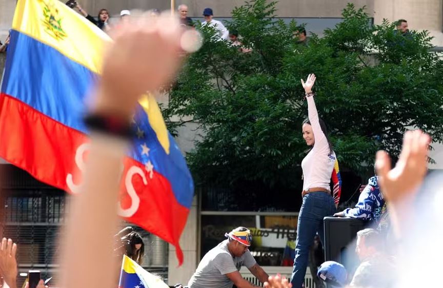 A líder da oposição venezuelana Maria Corina Machado acena durante um protesto convocado pela oposição na véspera da posse presidencial, em Caracas, em 9 de janeiro de 2025