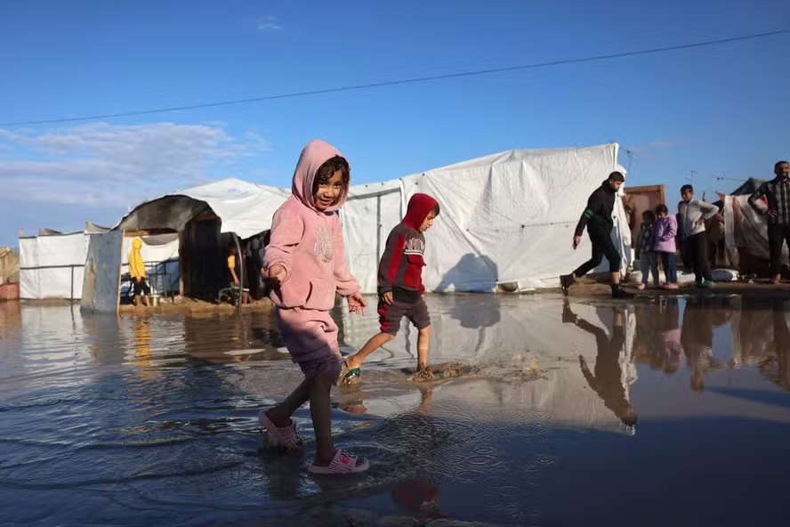 Crianças palestinas caminham em campo de refugiados de Khan Younis, na Faixa de Gaza 