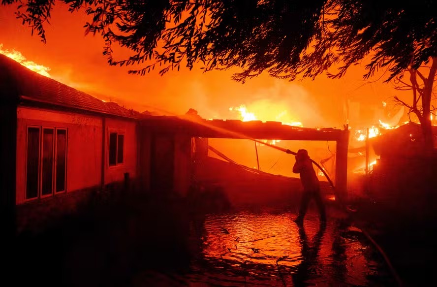 Um bombeiro apaga as chamas durante o incêndio de Eaton em Pasadena, Califórnia 