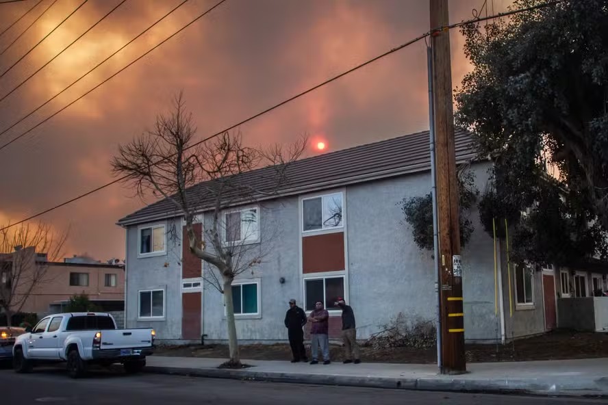 Moradores saem de suas casas enquanto o céu é preenchido pela fumaça do incêndio em Hughes em Castaic, no noroeste de Los Angeles 