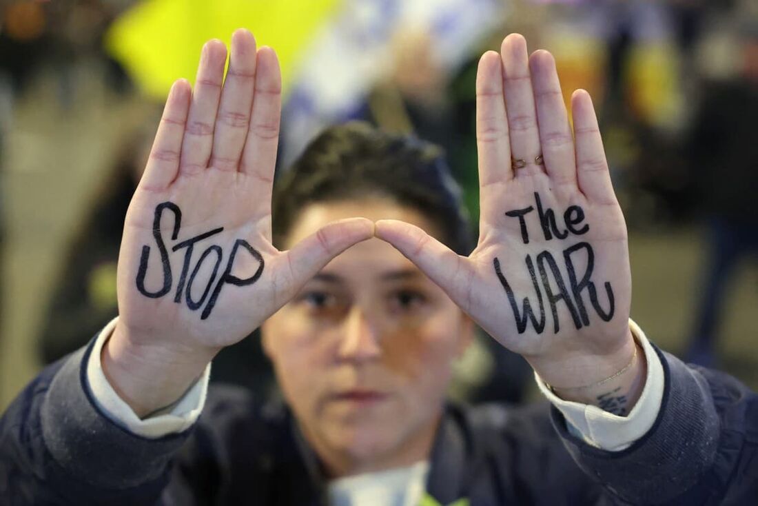 Uma manifestante levanta as mãos para exibir uma mensagem durante um protesto pedindo a libertação de reféns mantidos em cativeiro em Gaza