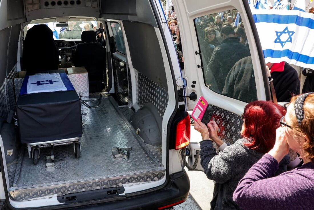 Pessoas em luto veem o corpo de Oded Lifshitz, um dos reféns israelenses feitos prisioneiros por militantes palestinos na Faixa de Gaza