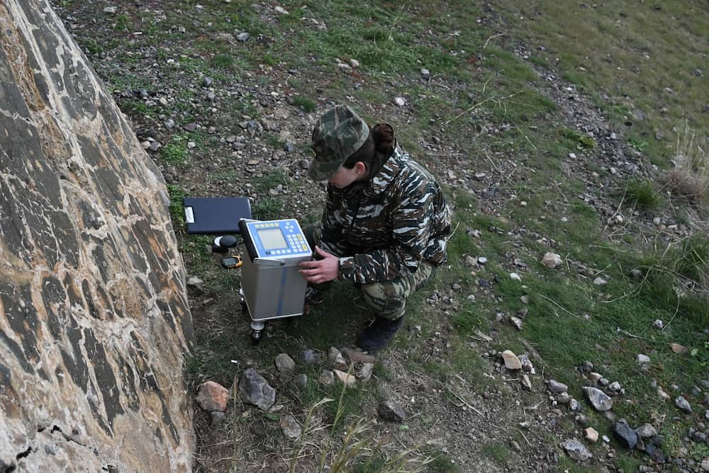 Um membro do serviço geográfico militar da Grécia faz medições na ilha vulcânica de Santorini