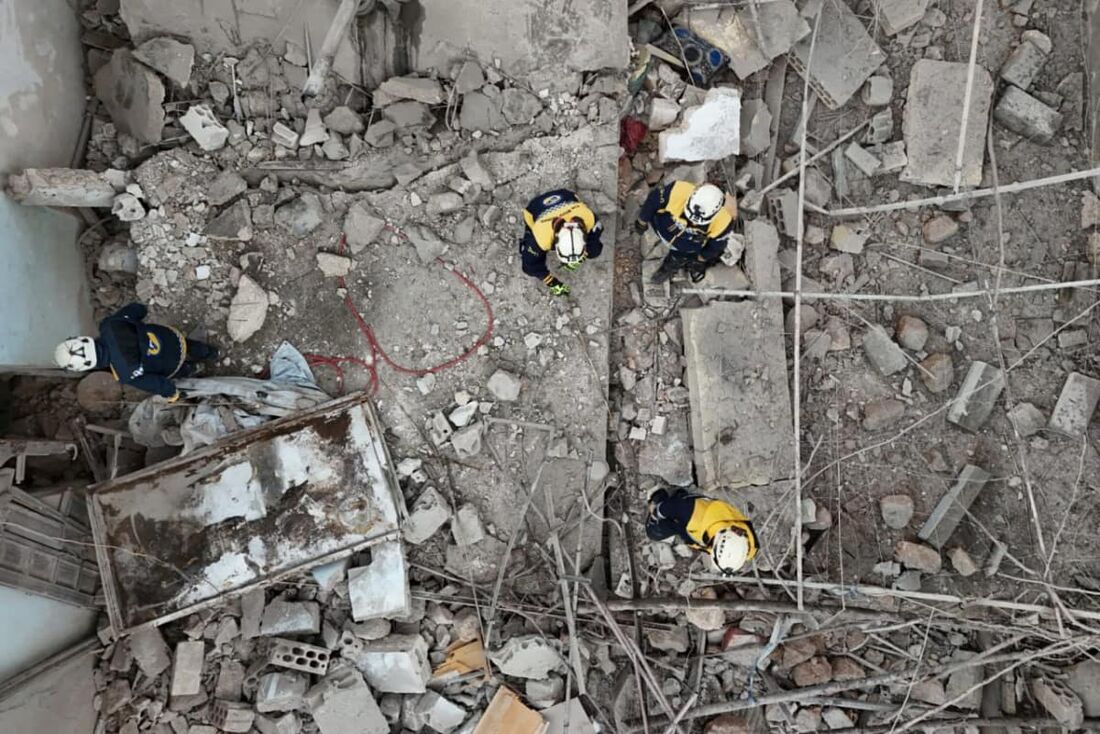 Uma equipe de resgate dos Capacetes Brancos inspeciona o local de uma explosão que ocorreu quando sobras de munições explodiram dentro de uma casa em Nayrab, na Síria