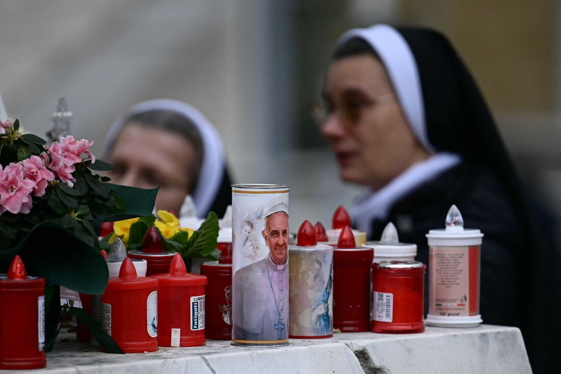 Uma vela com um retrato do Papa Francisco do lado de fora do hospital onde o pontífice está hospitalizado, em Roma