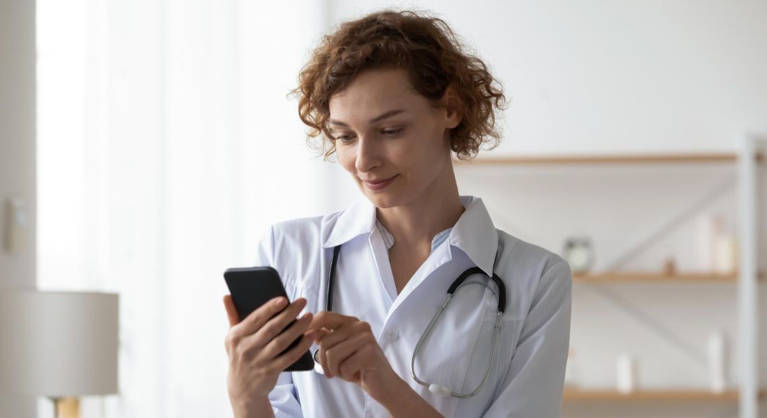 Médica olhando o celular