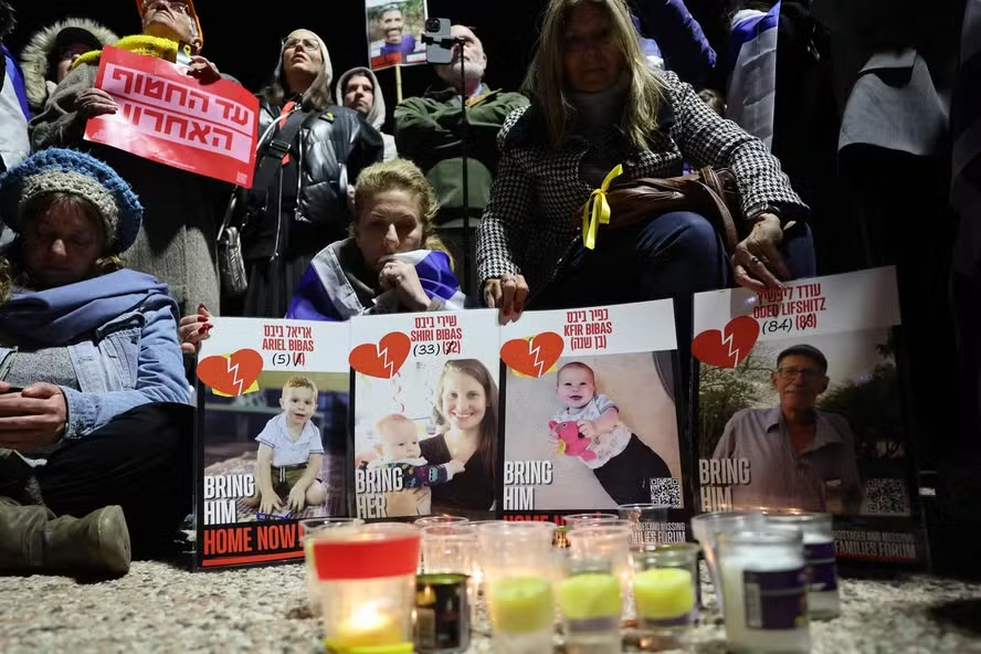 Pessoas com cartazes dos quatro reféns cujos restos mortais foram entregues pelo Hamas, durante protesto em Tel Aviv