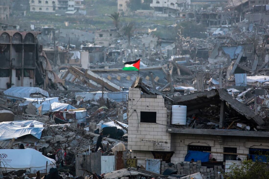Bandeira da Palestina em meio às ruínas de edifícios em Beit Lahia, no norte da Faixa de Gaza
