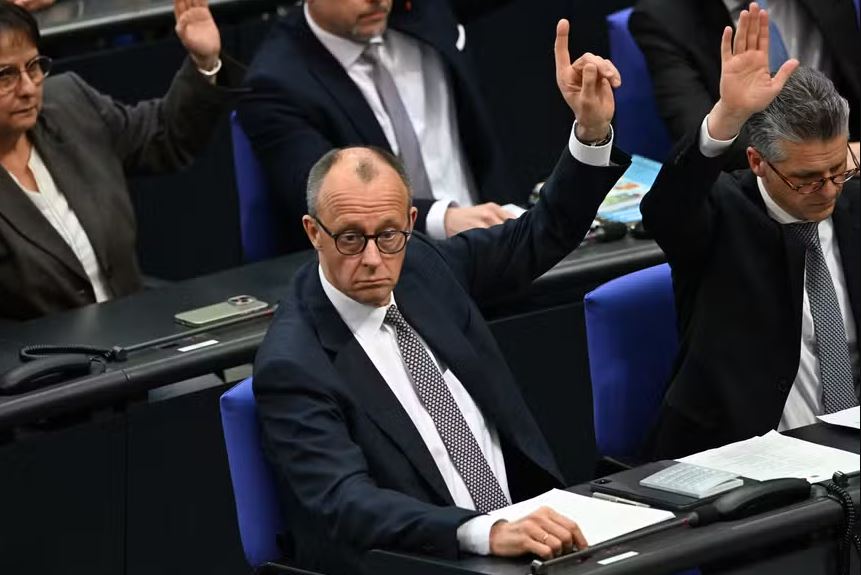 Friedrich Merz, líder do partido conservador alemão CDU, levanta a mão durante a votação no Bundestag