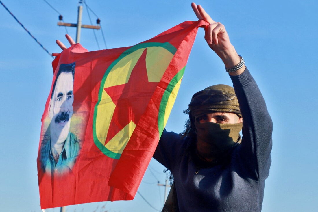 Uma mulher curda iraquiana acena uma bandeira com o retrato do fundador do Partido dos Trabalhadores do Curdistão (PKK), Abdullah Ocalan