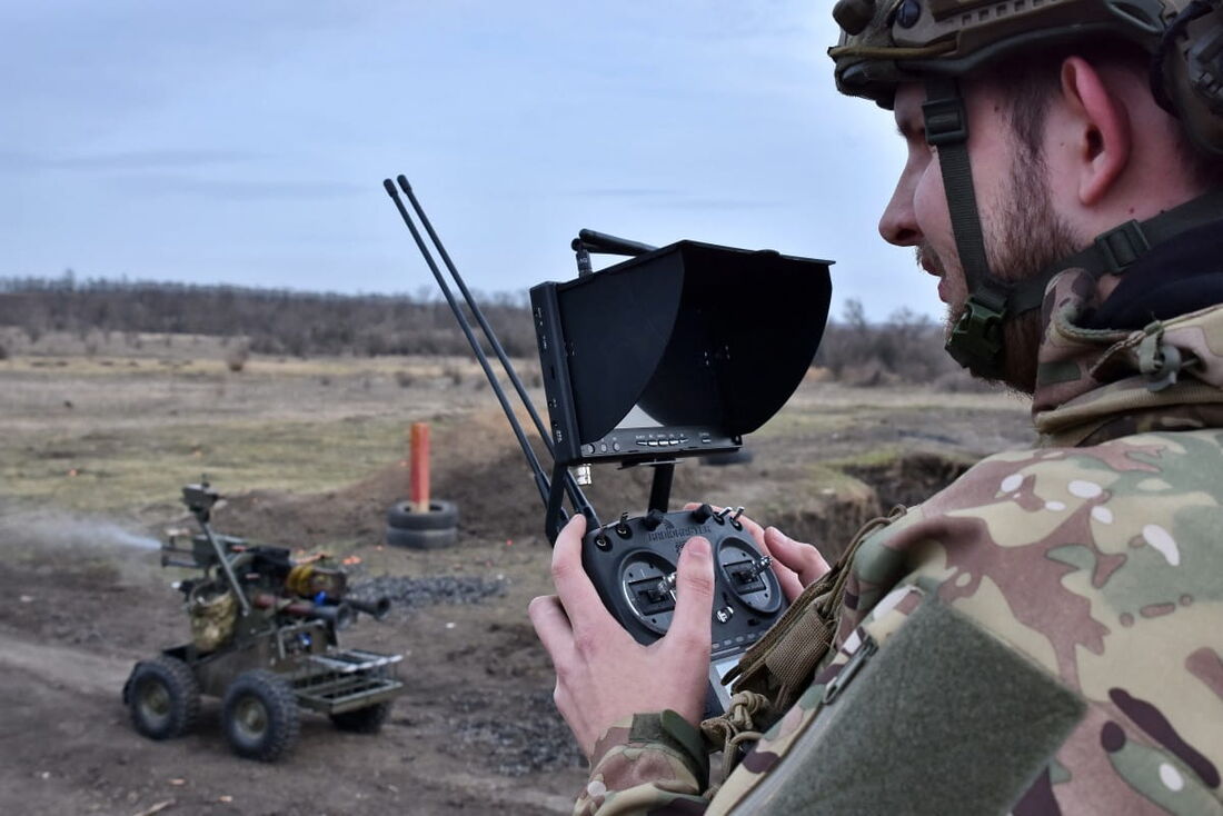 Militar ucraniano examinando um veículo terrestre não tripulado em um campo de treinamento militar na região de Zaporizhzhia