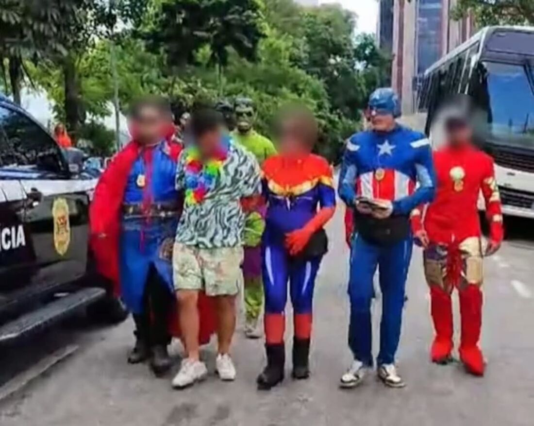 Policiais civis fantasiados prendem dois homens em flagrante em meio à foliões. 