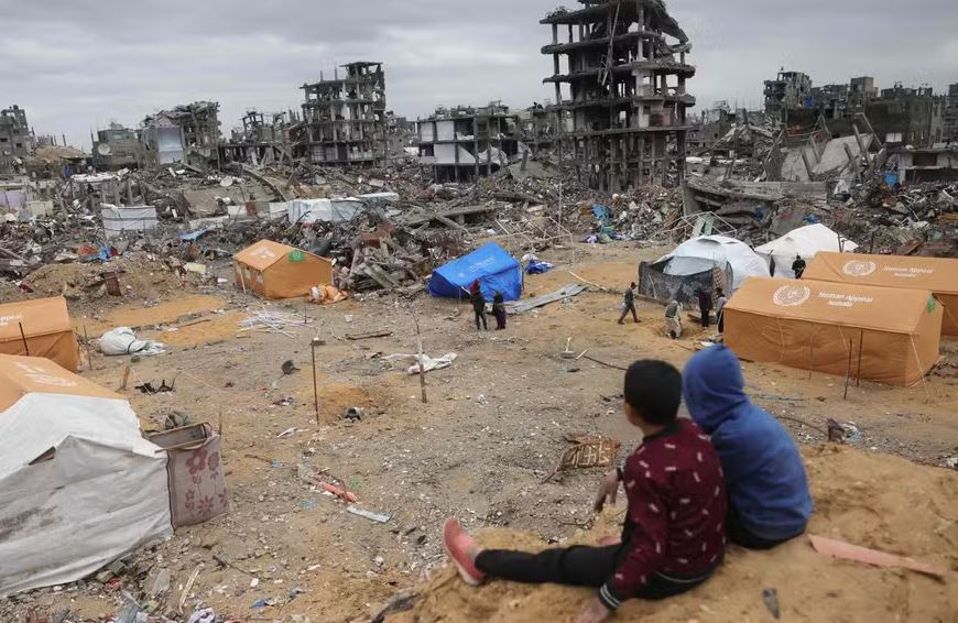 Crianças palestinas desabrigadas olhando para as tendas em meio aos destroços de Jabalyia, no norte da Faixa de Gaza 