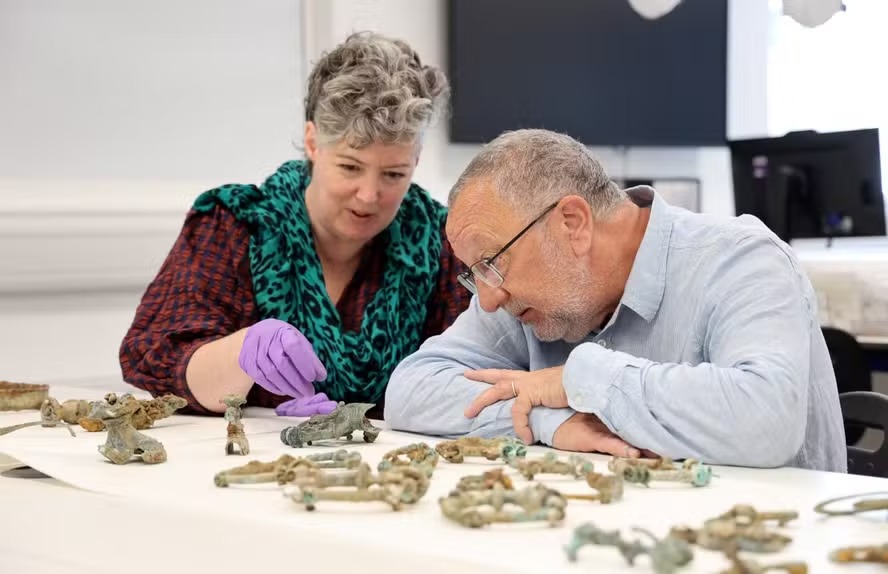 Na fotografia, a curadora do Museu Britânico Sophia Adams e o inspetor de monumentos antigos Keith Emerick analisam um dos 800 objetos da Idade do Ferro