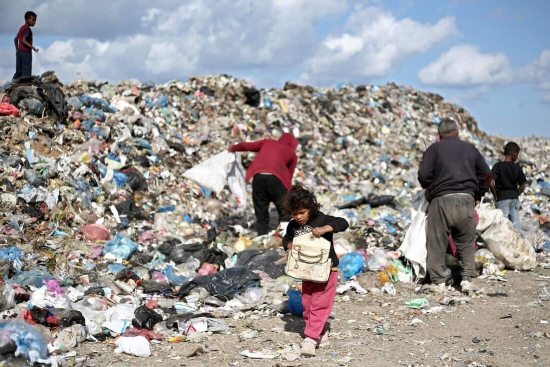 Crianças palestinas vasculham o lixo em um aterro sanitário no campo de refugiados de Bureij, no centro da Faixa de Gaza
