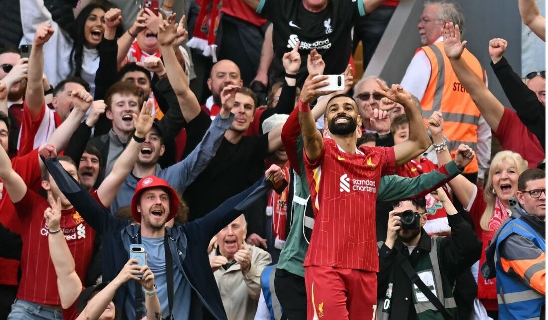 O atacante Mohamed Salah faz selfie com a torcida do Liverpool