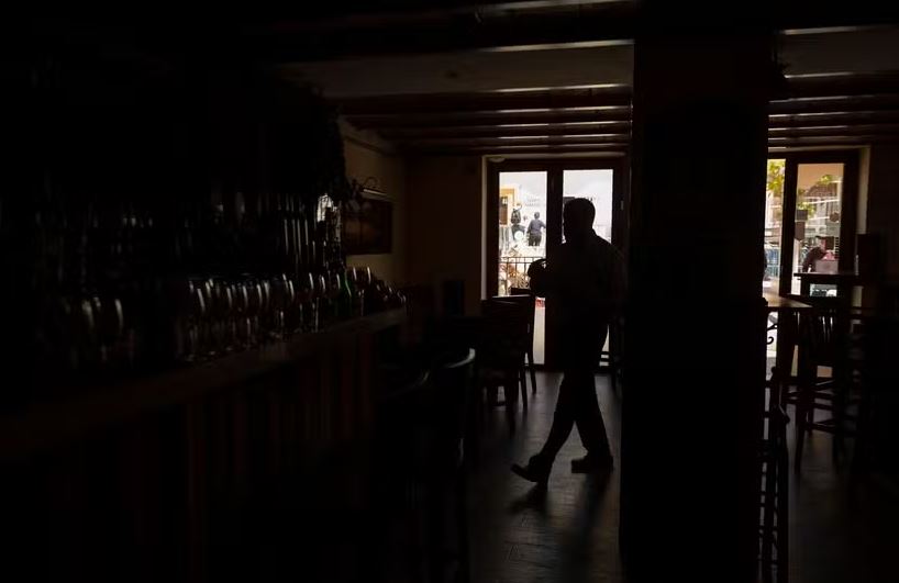 Um barman trabalha no restaurante "La Taberna" sem luz durante um grande apagão que afetou toda a Península Ibérica e o sul da França. 