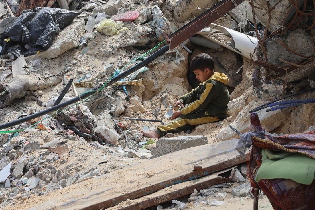 Um menino palestino brinca em meio aos escombros de um prédio destruído durante a guerra entre Israel e o Hamas, na Cidade de Gaza
