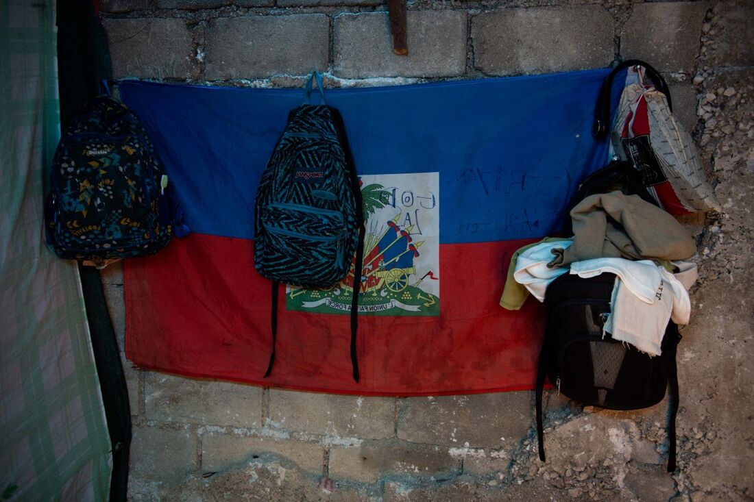 Mochilas e pertences de uma família que fugiu da violência de gangues estão pendurados na parede de um abrigo recém-inaugurado perto do Palácio Nacional em Porto Príncipe, Haiti, em 31 de março de 2025.