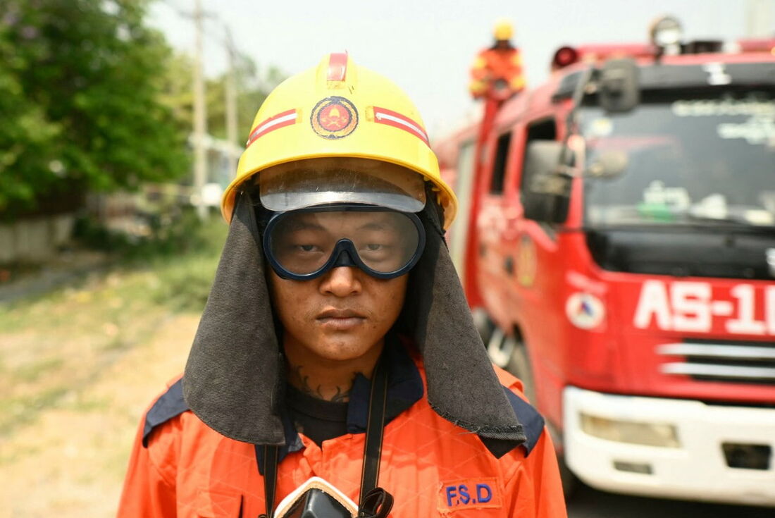 Um oficial de resgate observa um minuto de silêncio perto do complexo Sky Villa Condominium, um dos locais mais afetados pelo terremoto de 28 de março, em Mandalay