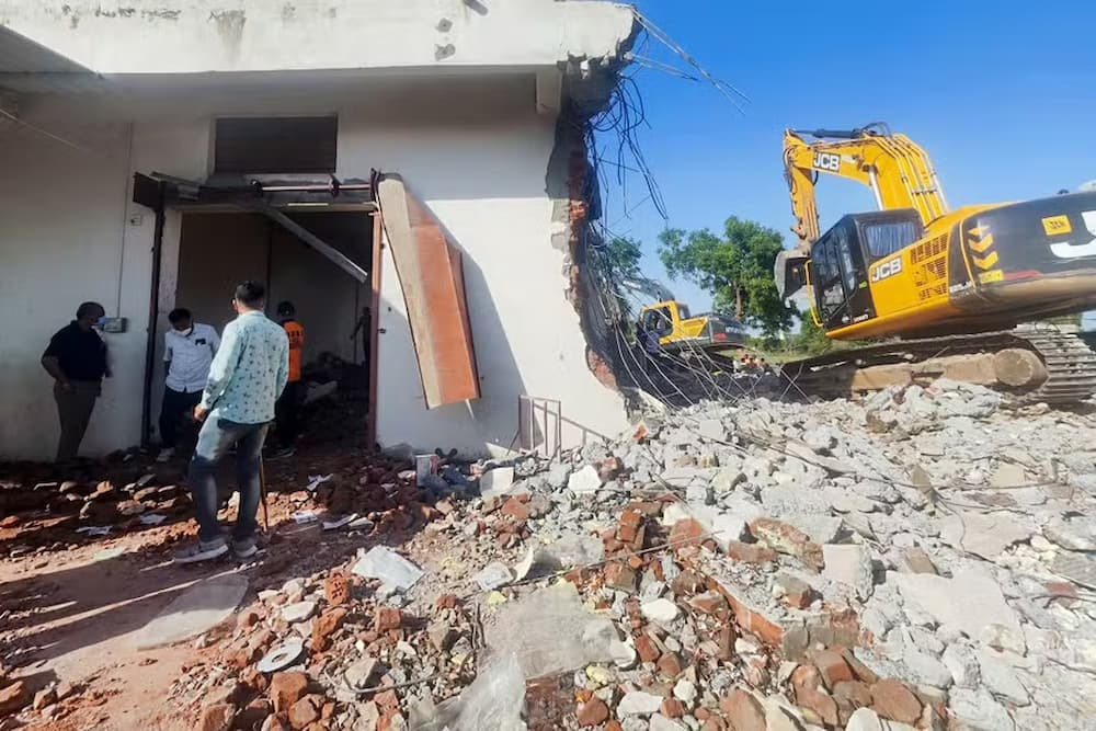 Pessoas em meio a destroços após explosão em uma fábrica de fogos de artifício