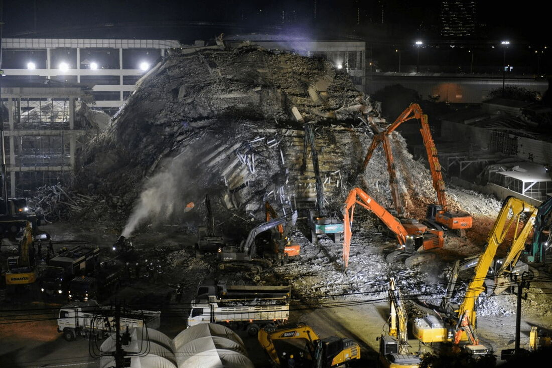 Máquinas pesadas são usadas para limpar escombros no local do colapso de um prédio em construção em Bangkok em 3 de abril de 2025