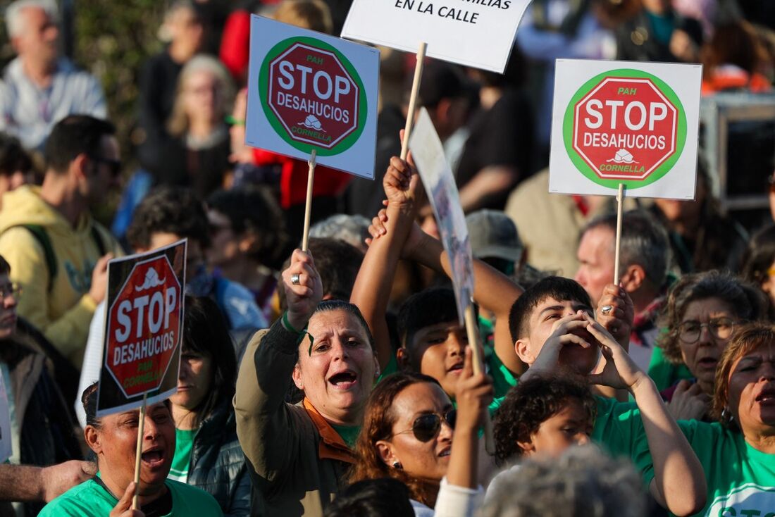 Manifestantes seguram faixas com os dizeres "Pare os despejos" durante uma manifestação nacional pelo direito à moradia digna, realizada simultaneamente em cidades da Espanha.